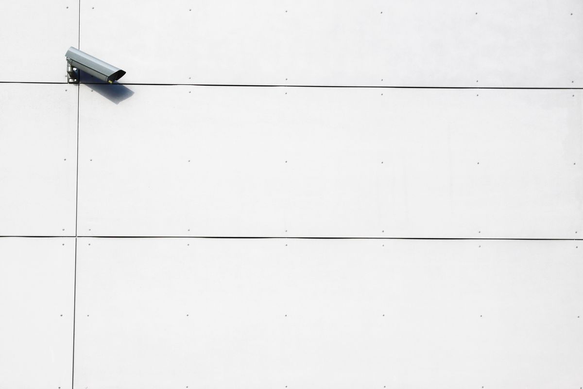 Wall-mounted outdoor security camera on a modern white home exterior