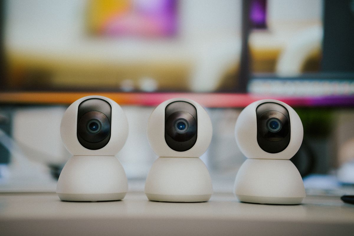 Three modern home security cameras side by side, illustrating how many security cameras a house needs